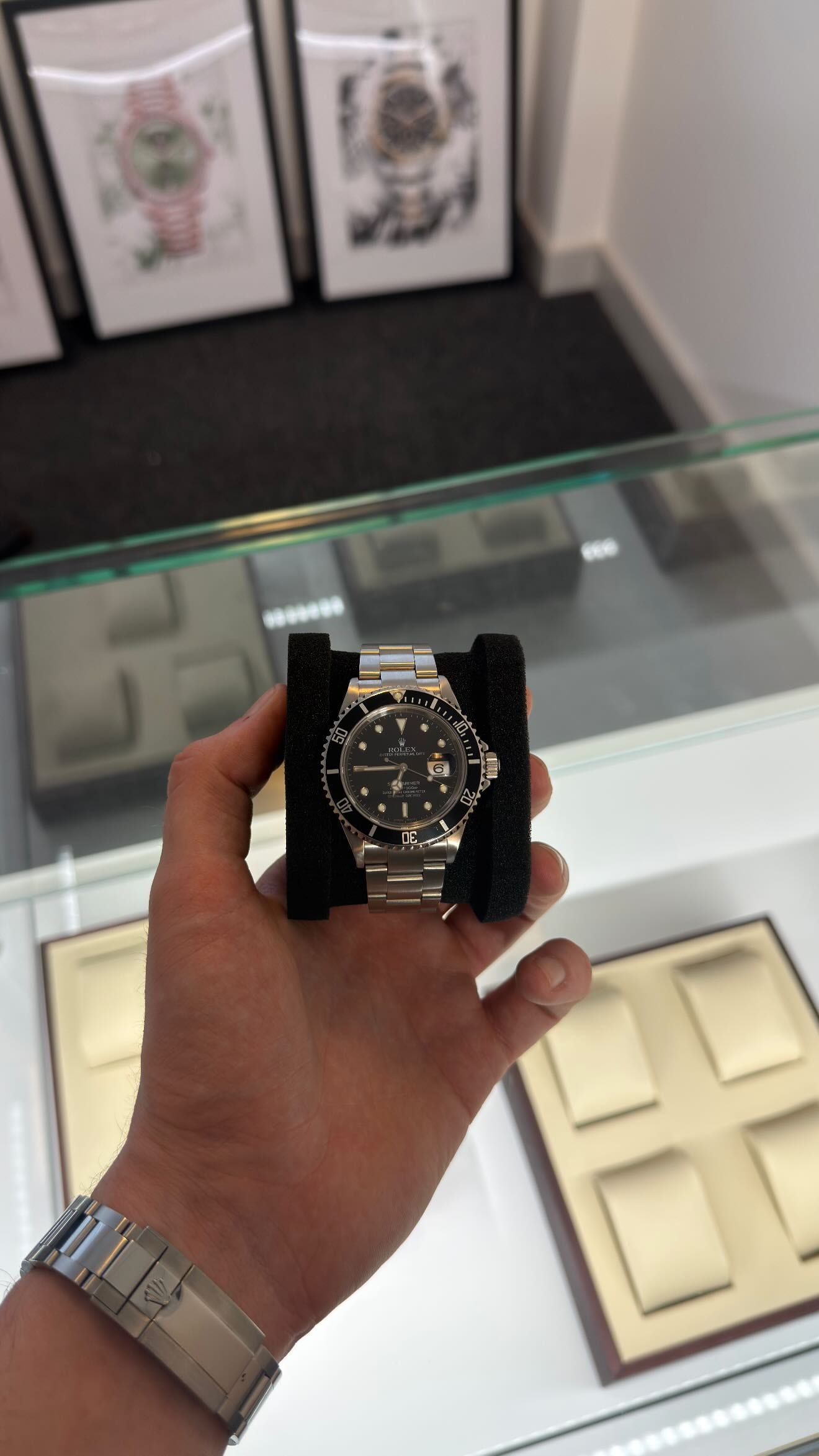 A vintage two-tone Rolex Submariner being inspected by hand